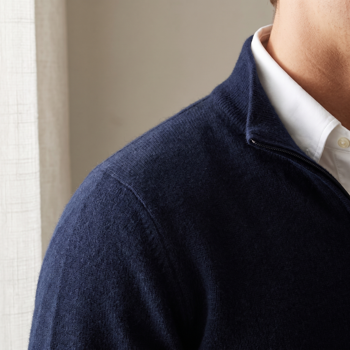 Close up of a navy knit quarter zip collar